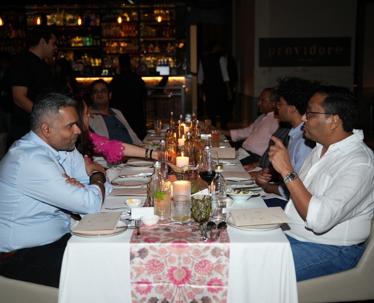 Members at a bar table late in the evening.