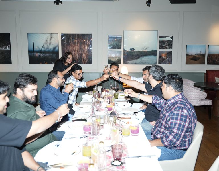 A long table mid-toast at a seated dinner.