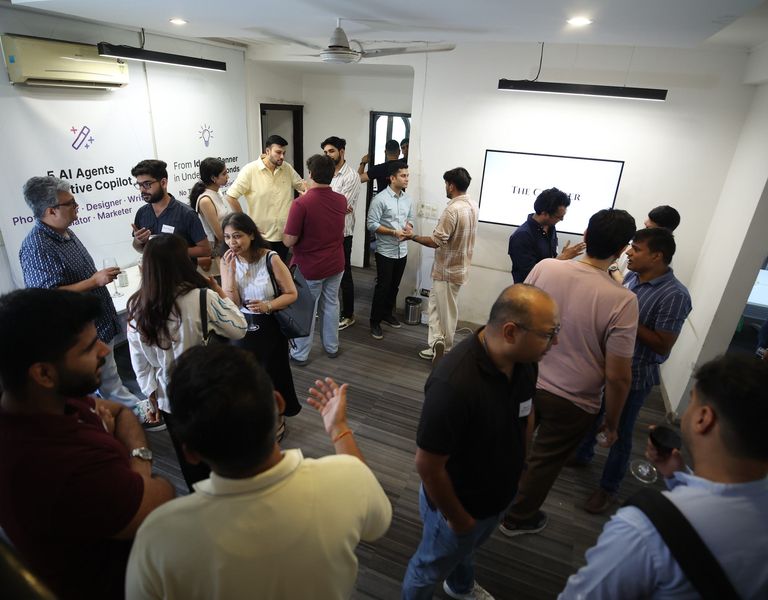 A crowded hiring floor with founders and candidates talking.